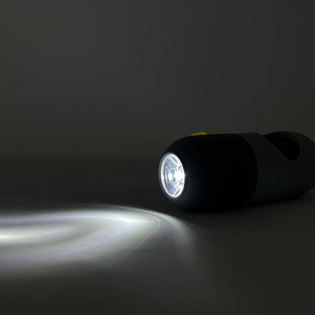 poop bag holder flashlight emitting light on a dark background
